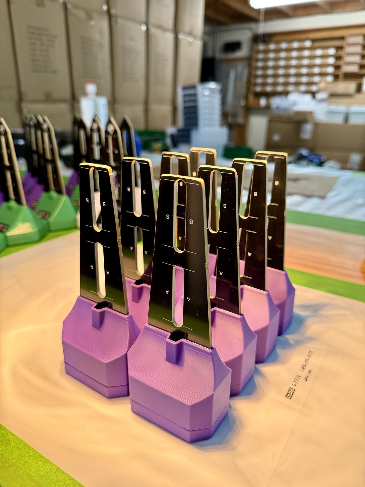 Batch of assembled BLADE sensors standing upside down on the bench with probes up, glue curing