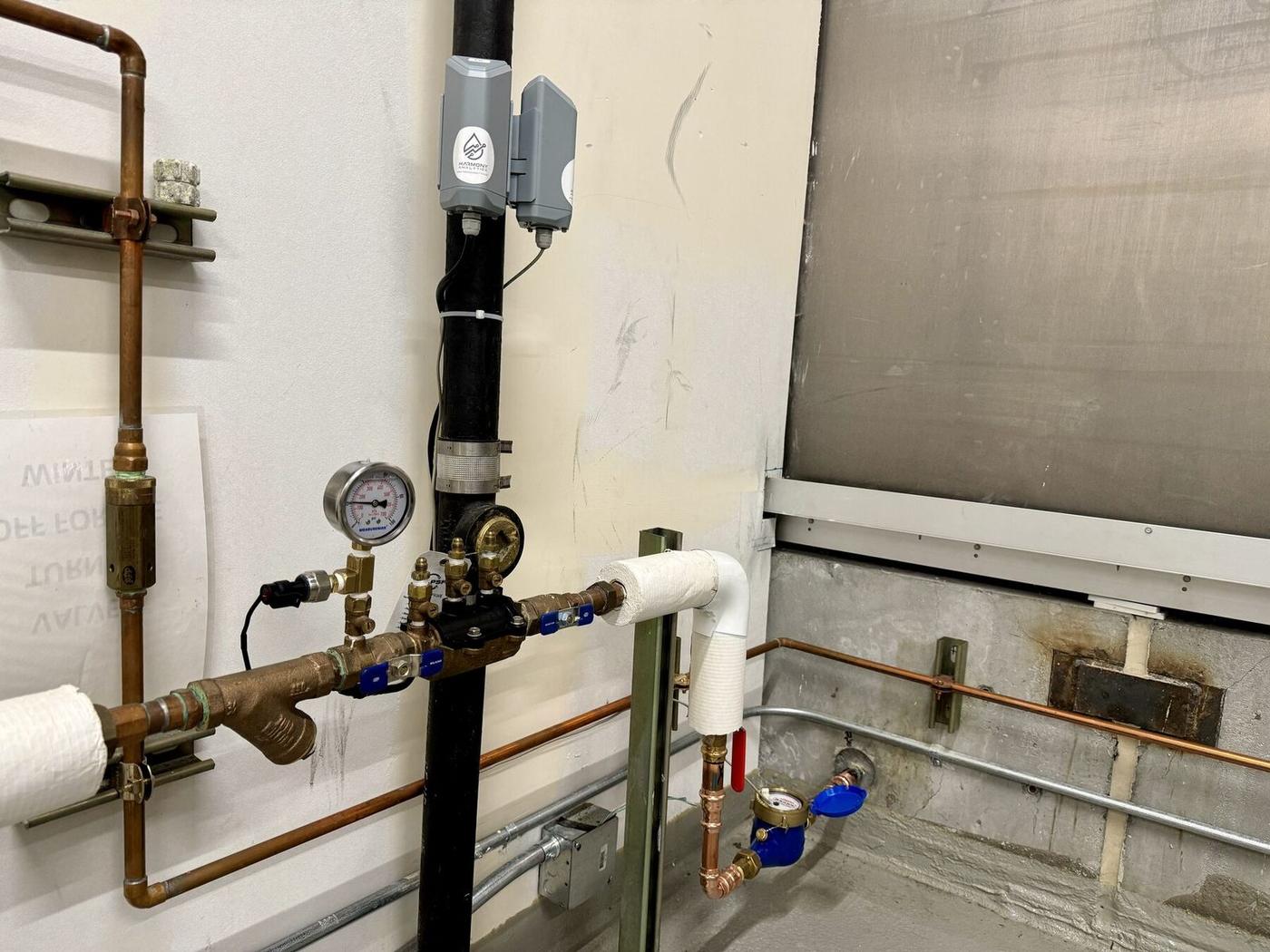 Water meter and pressure sensor retrofit on building plumbing